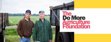 Image of two farmers standing near trucks with The Do More Agriculture Foundation logo 